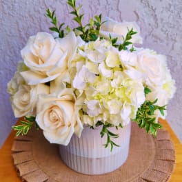 White roses and hydrangeas in a white vase