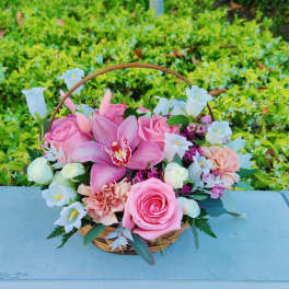 Pink and white flower basket with roses and a large orchid