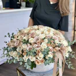 Large dome bouquet of cream and blush roses in a round vase