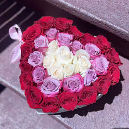 Heart-shaped box filled with red, pink, and white roses