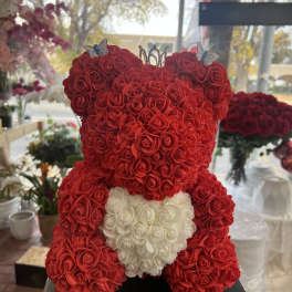 Red rose teddy bear with a white heart on a black base