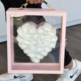 White roses arranged in a heart-shaped pink display box