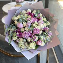 Bouquet of pink and white roses with eucalyptus in pastel wrapping