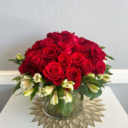 Red roses and white alstroemeria in a clear glass vase