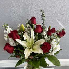 Red roses and white lilies arranged in a clear glass vase