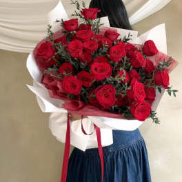 Large bouquet of red roses wrapped in white and red paper
