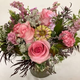 Pink rose bouquet in a glass vase with mixed blooms