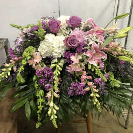 Large floral spray with pink lilies, purple roses, and white hydrangea
