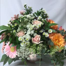 Mixed bouquet of pink and orange flowers in a vase