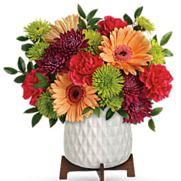 Colorful mixed bouquet in a white textured vase on a wooden stand