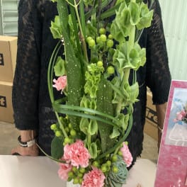 Tall green floral arrangement with pink carnations and berry accents