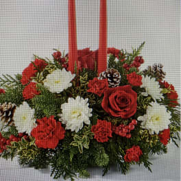 Red and white floral centerpiece with two tall red candles