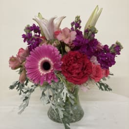 Pink and purple mixed bouquet in a clear glass vase