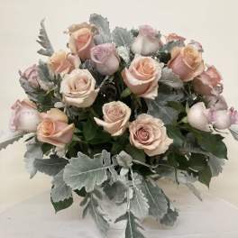 Bouquet of blush and peach roses in a clear vase
