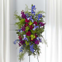 Tall standing floral spray with blue, purple, and green flowers