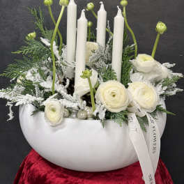 White floral arrangement with candles in a bowl-shaped vase