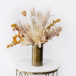 Dried floral arrangement in a gold vase with beige and mustard tones