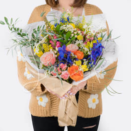 Large mixed bouquet with colorful flowers wrapped in paper