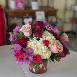 Mixed pink and white flower bouquet in a small glass vase