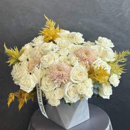 White rose bouquet with pale pink blooms in a gray vase
