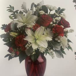 Bouquet of red roses and white lilies in a red vase