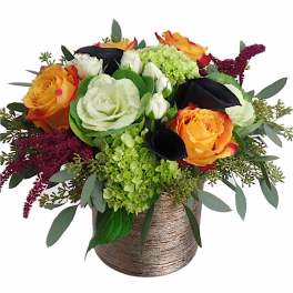 Orange and white roses with green hydrangea in a textured vase