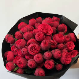 Bouquet of red roses wrapped in black paper with a red ribbon
