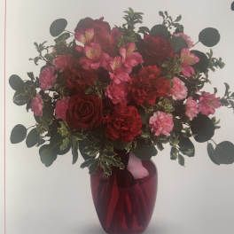 Red and pink bouquet in a red glass vase