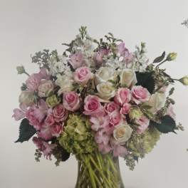 Pink and white rose bouquet in a clear glass vase