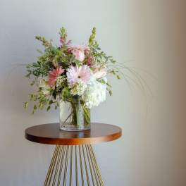 Pink and white flower arrangement in a clear glass vase