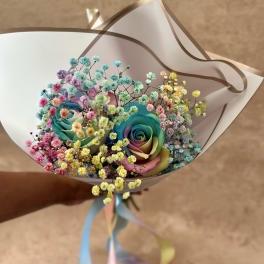 Bouquet of rainbow-colored roses with pastel baby's breath
