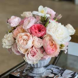 Pink and white rose bouquet in a decorative urn vase