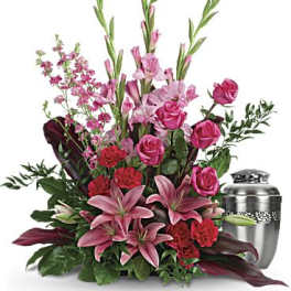 Pink lilies and roses arranged beside a silver urn
