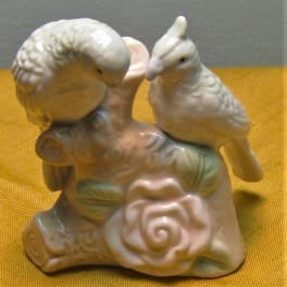 Ceramic bird figurine on a floral base