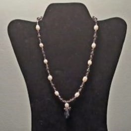 Beaded necklace displayed on a black bust stand