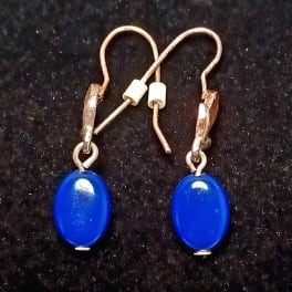 Pair of blue oval drop earrings on a dark background