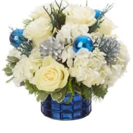 White roses and hydrangeas in a blue glass vase with blue ornaments