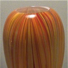 Tall striped glass vase in orange, red, and yellow tones