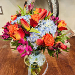 Colorful bouquet of roses, hydrangeas, and alstroemeria in a glass vase