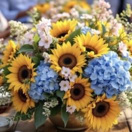 Sunflowers and blue hydrangeas in a low arrangement