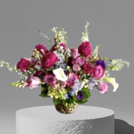Mixed bouquet of pink, white, and purple flowers in a woven vase