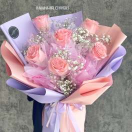 Pink roses with baby's breath in pastel lavender and peach wrapping