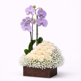 Cream roses and lavender orchids in a wooden box