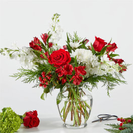 Red and white floral arrangement in a clear glass vase