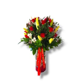Bouquet of red roses and yellow lilies in a glass vase