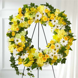Yellow and white floral wreath on a black stand