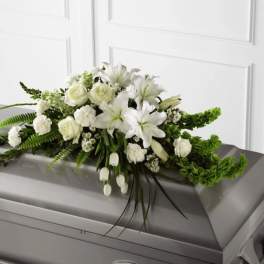 White floral casket spray with lilies and roses