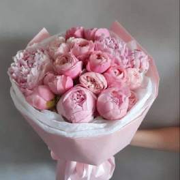 Pink bouquet of peonies and tulips wrapped in pastel paper