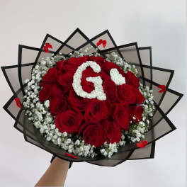 Bouquet of red roses with white baby's breath and a floral letter G