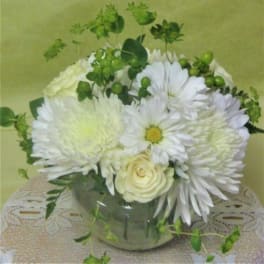 White daisies and roses arranged in a glass vase